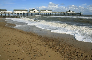 Piers Prints: View of beach and restored pier with rough sea