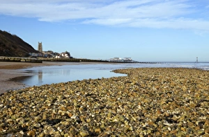 View of beach with seaside town and pier in background, Cromer, Norfolk, England, february