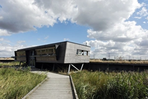 View of boardwalk and birdwatching hide in marshland, Rainham Marshes RSPB Reserve, Thames Estuary, Essex, England