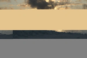 View of boats on intertidal mudflats habitat at sunset, looking towards Grange-over-sands in Cumbria from Morecambe