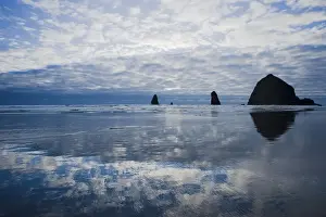 Stacks Prints: View of clouds reflected on shore and distant sea stacks at dusk
