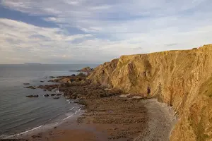 Cliff Prints: View of coastal cliff with folded strata in late afternoon sunlight