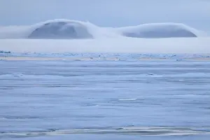 View of coastal ice floes, with fog covered mountains in background, Spitsbergen, Svalbard, september