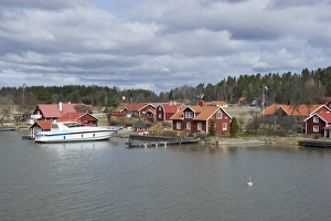 Baltic Prints: View of coastal settlement with boat in harbour, Bjorsund, Sodermanland, Sweden, april