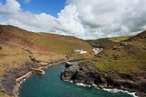 Quay Prints: View of coastline with breakwater and old quay in foreground leading to village in valley