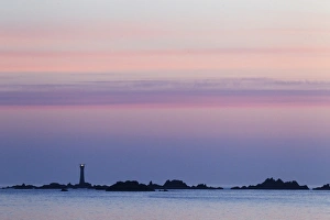 Lighthouse Prints: View of coastline with lighthouse at sunset, L Eree Bay, Guernsey, Channel Islands, May