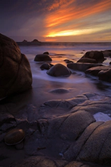 View of eroded rock formations on beach at sunset, near Lands End, Cornwall, England