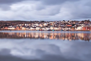 Rains Prints: View across estuary at high tide towards town with glow from lights