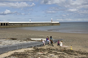 Woman Prints: View of family on beach with jetty and lighthouse in background, Ramsey, Isle of Man, june