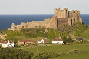 Castles Prints: View fields and village towards castle, Bamburgh Castle, Northumberland, England, may