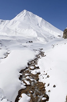 Melts Prints: View of flowing stream along snow covered mountain valley