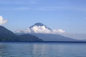 Cone Prints: View of forest covered volcano cone on shores of coastal bay