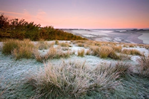 View of frost covered moorland habitat at sunrise, with mist rising from valley, looking towards River Barl