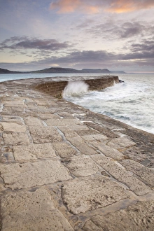 Editor's Picks: View of harbour wall with waves breaking at sunrise