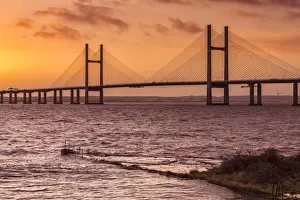 View of jetty, harbour wall and road bridge during very high tide and stormy conditions at sunrise, Sudbrook Jetty