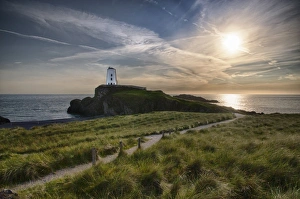 View of lighthouse and coastline on tidal island, Llanddwyn Island, Newborough Warren National Nature Reserve