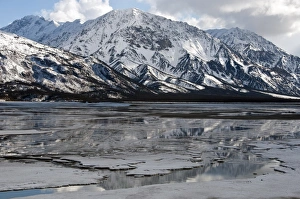 Peak Prints: View of melting ice on lake and snow covered mountains