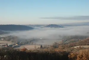 Medieval Prints: View of mist shrouded landscape with medieval bastide town on hill
