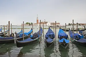 Religions Prints: View of moored gondolas across waterway towards 16th century Benedictine church
