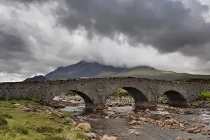 Peak Prints: View of moorland river with old Sligachan Bridge and mountains