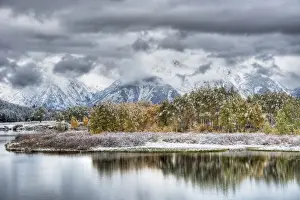 View of mountain range and forested river valley with trees in autumn colour and snow, Oxbow Bend, Grand Teton N. P