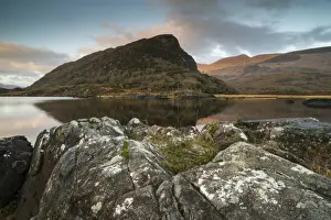 : View of mountain reflected in narrow channel connecting lakes at sunrise