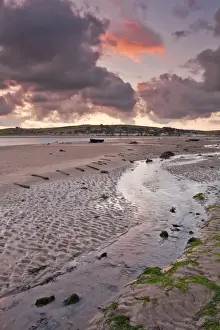 Trending: View of rainclouds gathering over sand banks of river estuary at sunrise