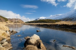 Highland Prints: View of river flowing through valley with snow covered mountains