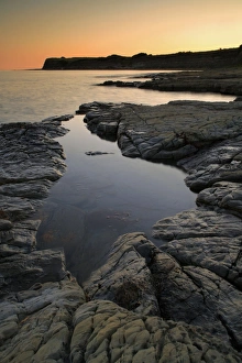 View of rockpool on beach at sunset, Hobarrow Bay, Isle of Purbeck, Dorset, England, july