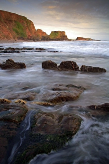 Cove Prints: View of rocks on beach in cove at sunset, Westcombe Beach, Devon, England