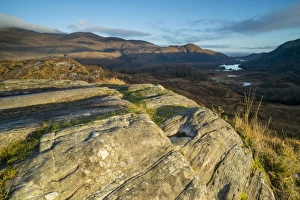 View over rocks on moorland towards lake and mountains at dawn, Ladies View, Lough Leane (Lower Lake)