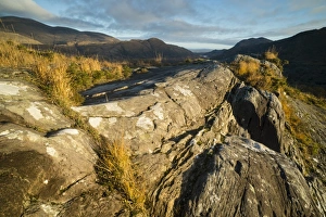 : View over rocks on moorland towards lake and mountains at dawn