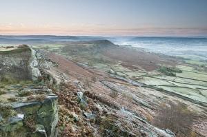 Frosted Prints: View of rocks and moorland across valley in frost at sunrise