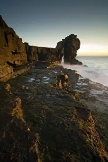 Stacks Prints: View of sea stack at sunset, created by quarrymen in 1870s after natural arch was cut away