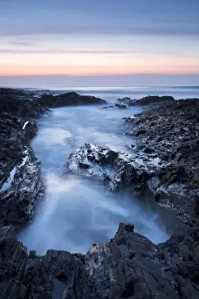 Tide Prints: View of sea washing into large rockpool during incoming tide at sunset