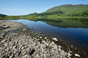 View of shore and hills reflected in freshwater loch, Loch Lubhair, near Crianlarich, Trossachs, Stirling, Scotland