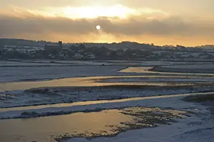 View of snow covered coastal grazing marsh habitat at sunset, Salthouse, Norfolk, England, december