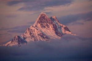 Peak Prints: View of snow covered mountain summit amongst clouds at sunset
