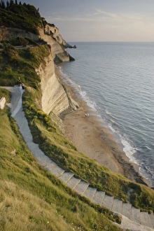 Steep Prints: View of steps down to beach from steep cliffs in evening sunlight