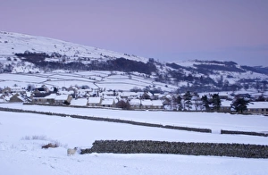 Swaledale Prints: View of village and fells in heavy snowfall at dusk