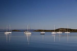 View of yachts moored in bay, with Small Isles in background, Craighouse Bay, Isle of Jura, Inner Hebrides, Scotland