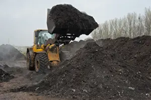Piles Prints: Volvo loader turning green compost waste for aeration at municipal waste site