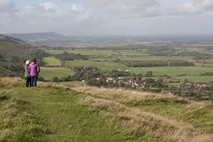 Woman Prints: Walkers standing at viewpoint overlooking village and farmland