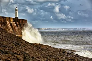 Seafronts Prints: Waves crashing against coastal resort town seafront and lighthouse