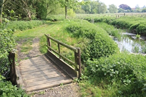 River Side Prints: Wooden footbridge on footpath beside lowland river