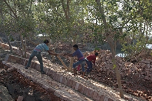 Flood Prints: Workers with bricks used for flood defence repairs