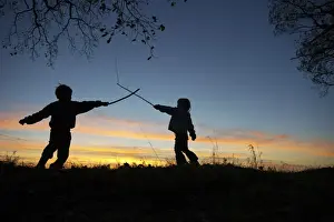 Sun Set Prints: Young children playing, having stick fight at edge of woodland