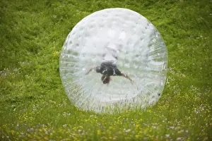 Northern Europe Prints: Zorbing, person rolling downhill in transparent plastic orb, Sweden, June